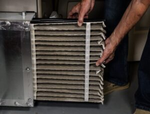 Low angle view of man holding air conditioner filter